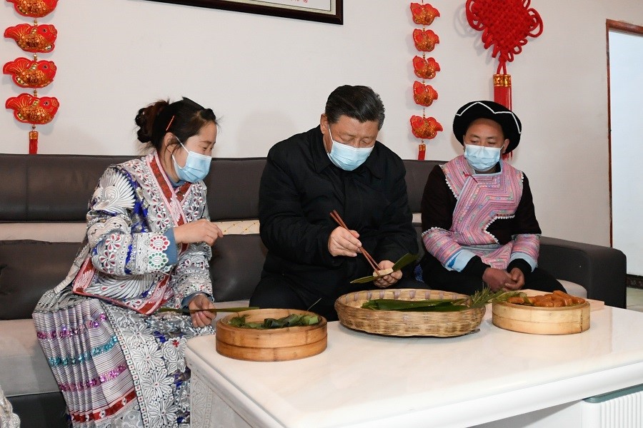 2021年2月3日下午，習(xí)近平在貴州畢節(jié)市黔西縣新仁苗族鄉(xiāng)化屋村苗族村民趙玉學(xué)家，同一家人邊聊家常邊制作當(dāng)?shù)貍鹘y(tǒng)節(jié)日食品黃粑。新華社記者 李學(xué)仁 攝